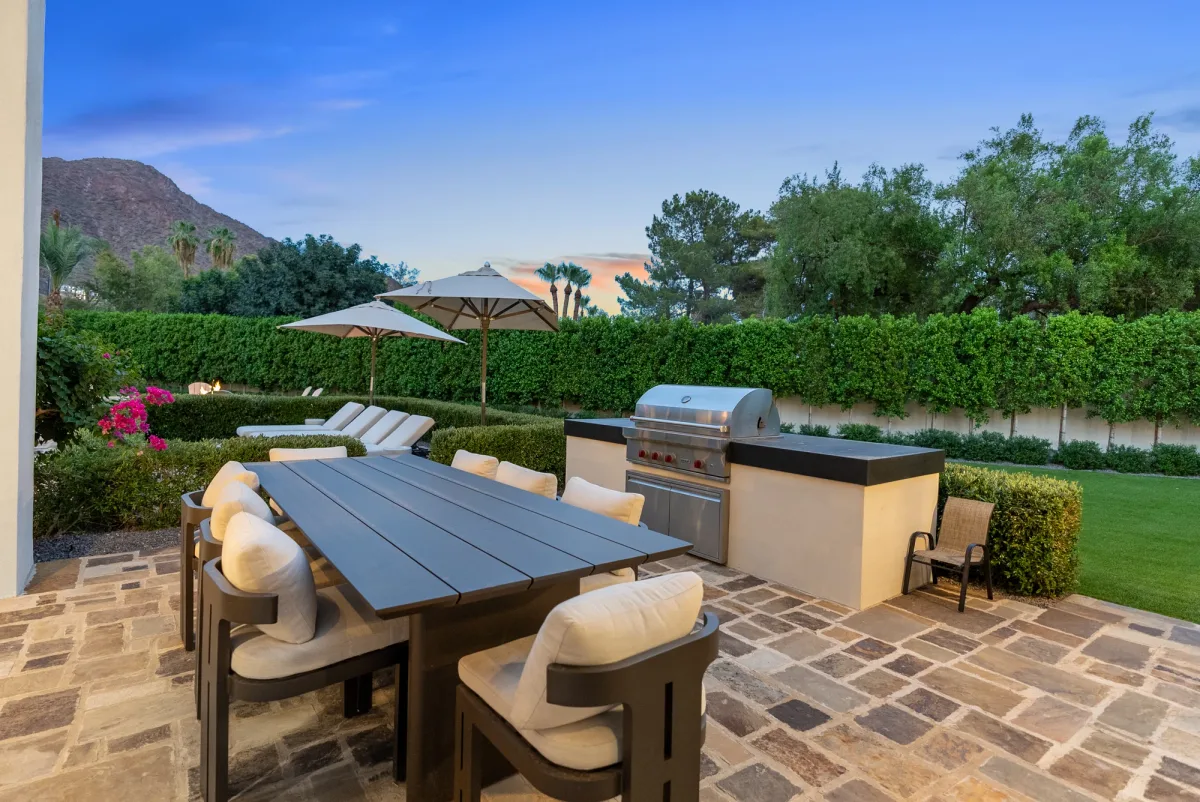 Outdoor dining table and built-in grill with a mountain backdrop