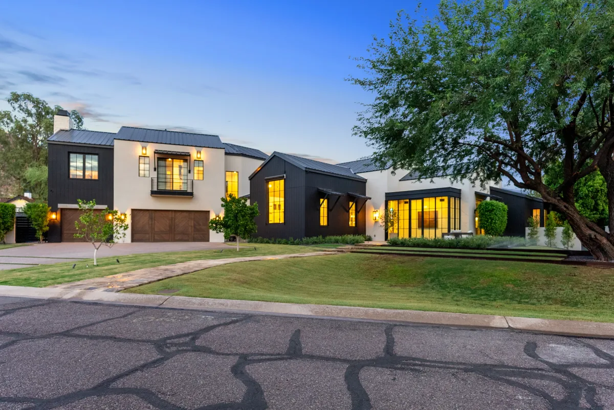 Dromedary front facade and uncluttered landscaped lawn at twilight