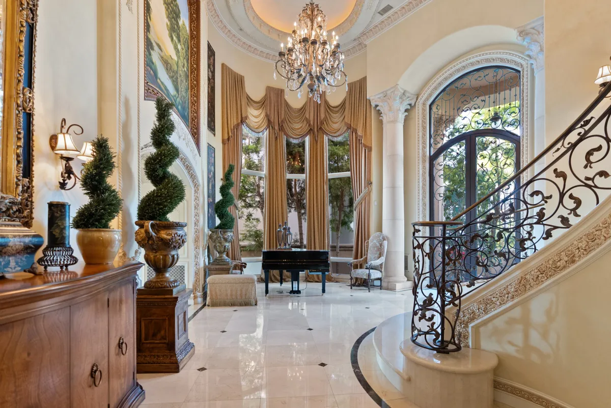 Grand entry with a curved staircase and tall arched front door