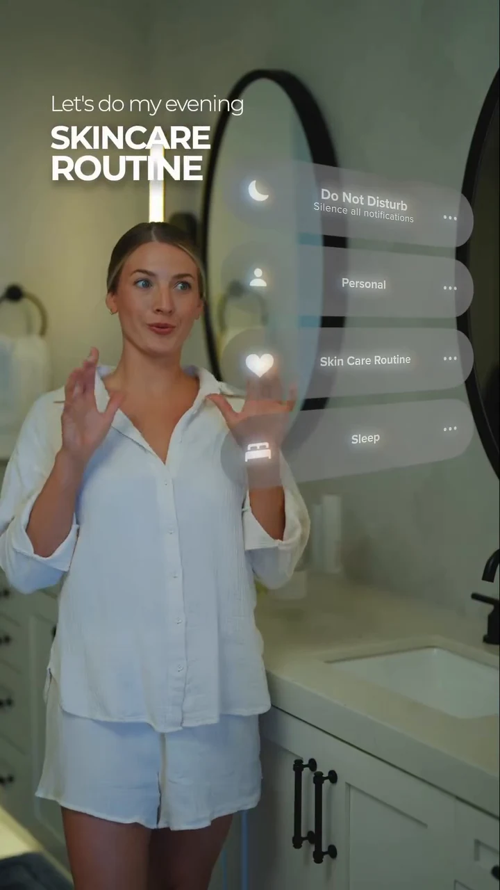 A woman demonstrating her evening skincare routine beside an oval mirror