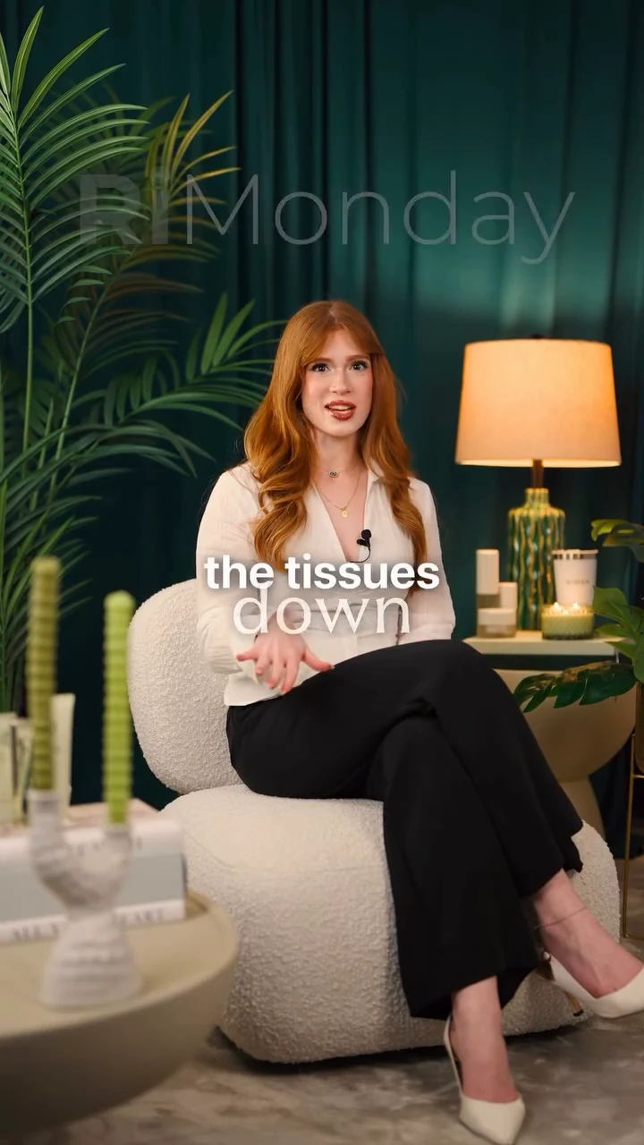 A red-haired presenter discussing skincare in a green-curtained studio