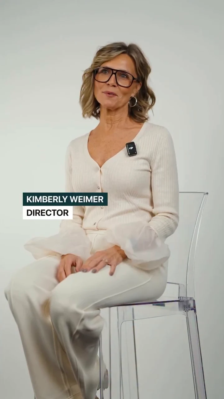 A woman in white discussing the brand while seated against a light backdrop
