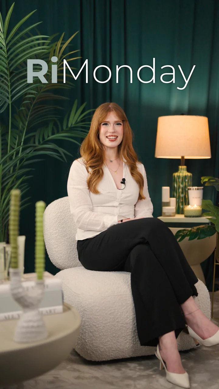 A smiling RiMonday presenter seated beside skincare products